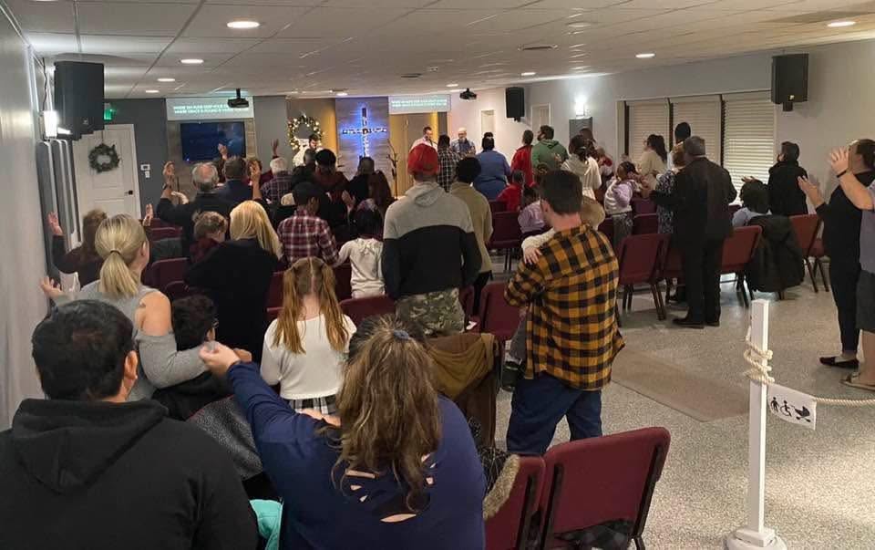 The Carisma Church family worshipping together on a Sunday, hands raised